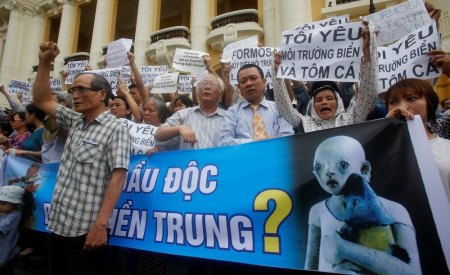 Demonstrators, holding signs to protest against Taiwanese enterprise Formosa Plastic and environmental-friendly messages, say they are demanding cleaner waters in the central regions after mass fish deaths in recent weeks, in Hanoi, Vietnam, May 1, 2016.