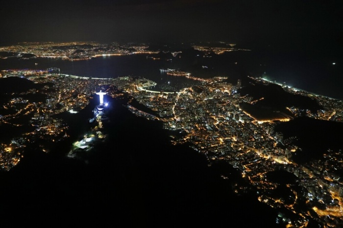 An aerial view of the Christ the Redeemer statue standing above Guanabara Bay.