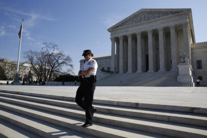 A U.S. Supreme Court police officer descends the steps outside the court in Washington, March 16, 2016. President Barack Obama on Wednesday will nominate Judge Merrick Garland for the Supreme Court, according to a congressional source familiar with the selection process. Garland currently serves as chief judge of the U.S. Court of Appeals for the District of Columbia.