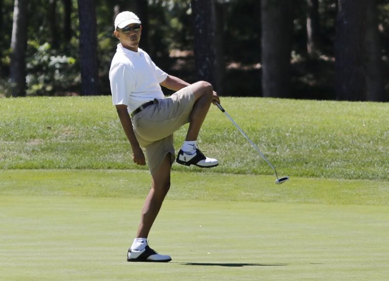 U.S. President Barack Obama reacts after missing a putt on the first green at the Farm Neck Golf Club at Oak Bluffs on Marthas Vineyard, August 11, 2013.