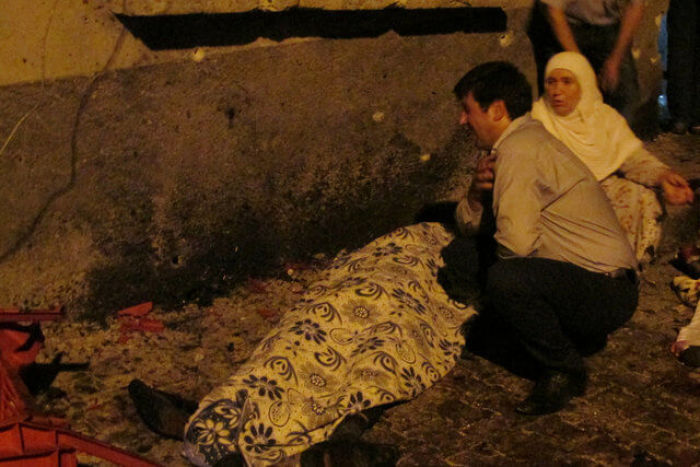 A man and a woman mourn next to a body of one the victims of a blast targeting a wedding ceremony in the southern Turkish city of Gaziantep, Turkey, August 20, 2016.