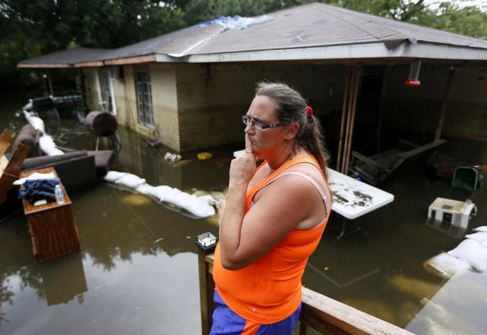 Amber James stands outside her mother's flooded home in St. Amant, Louisiana, U.S., August 20, 2016.