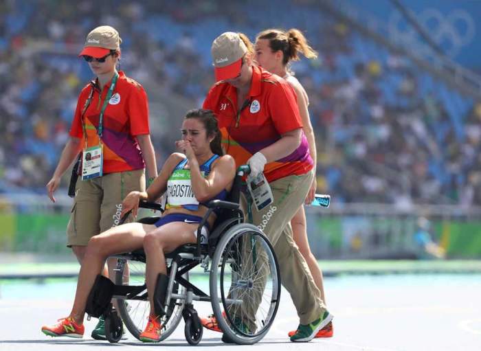 Abbey D'Agostino of USA is helped from the track after finishing the race at the Rio Olympics 2016 in Brazil on August 16, 2016.