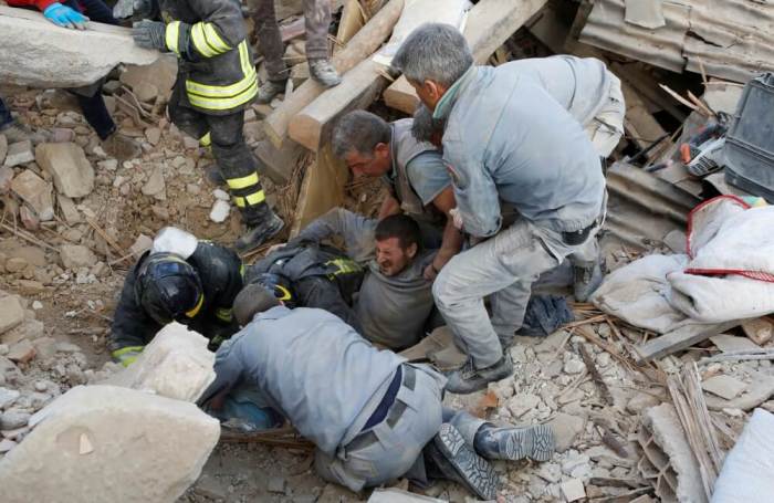 A man is rescued alive from the ruins following an earthquake in Amatrice, central Italy, August 24, 2016.
