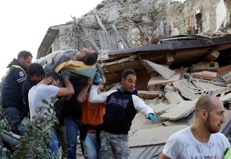 A man is carried away after having been rescued alive from the ruins following an earthquake in Amatrice, central Italy, August 24, 2016.